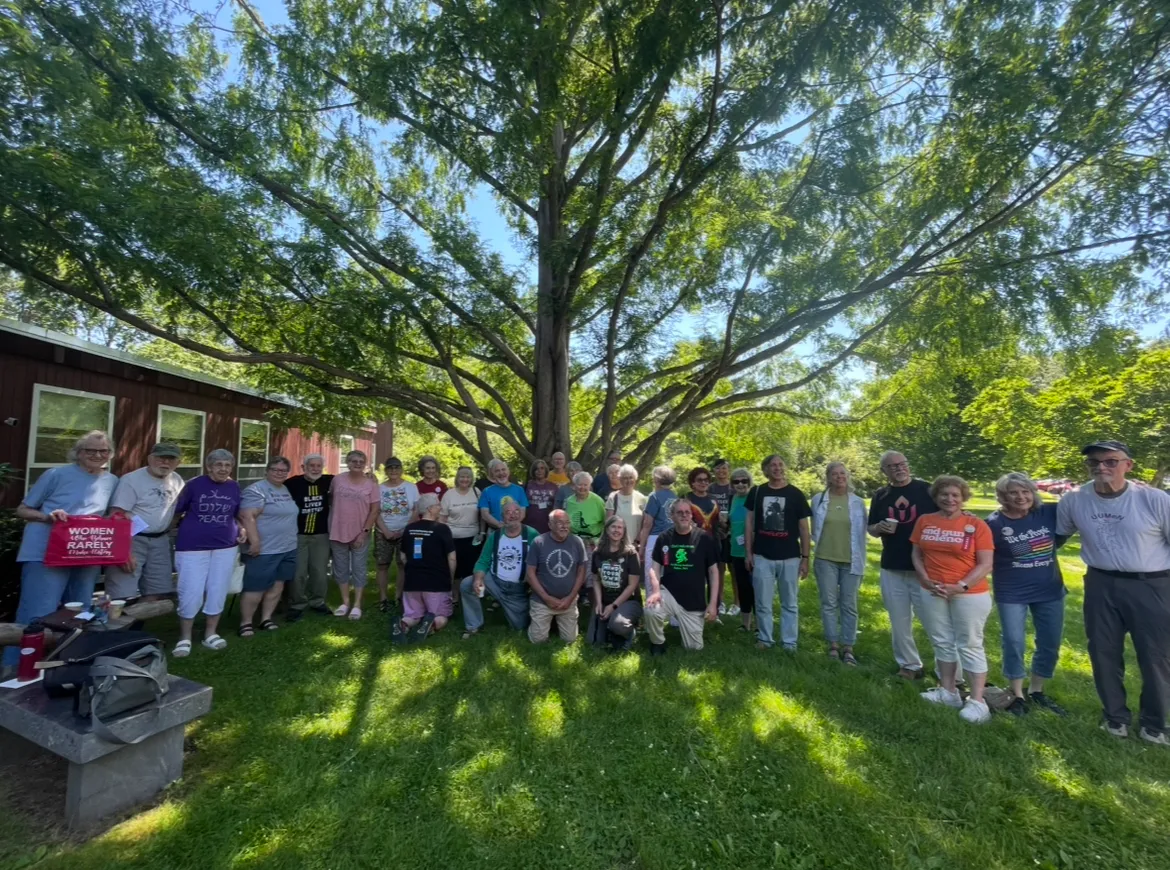Community members gathered beneath the Dawn Redwood tree beside the church.